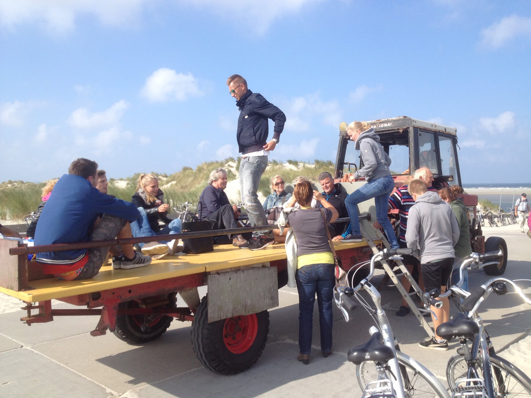 Strandritten met tractor en platte wagen op Ameland